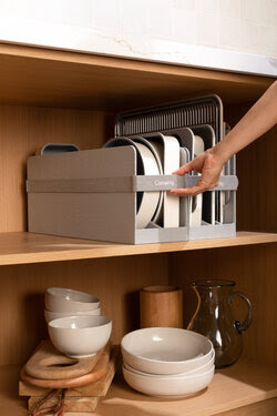 A set of caraway cookware on a shelf - cream pots and pans.